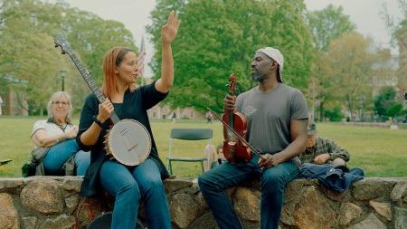 Rhiannon Giddens and Justin Robinson play instruments outside Wilson Library