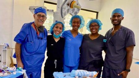 Five individuals posing wearing medical scrubs.